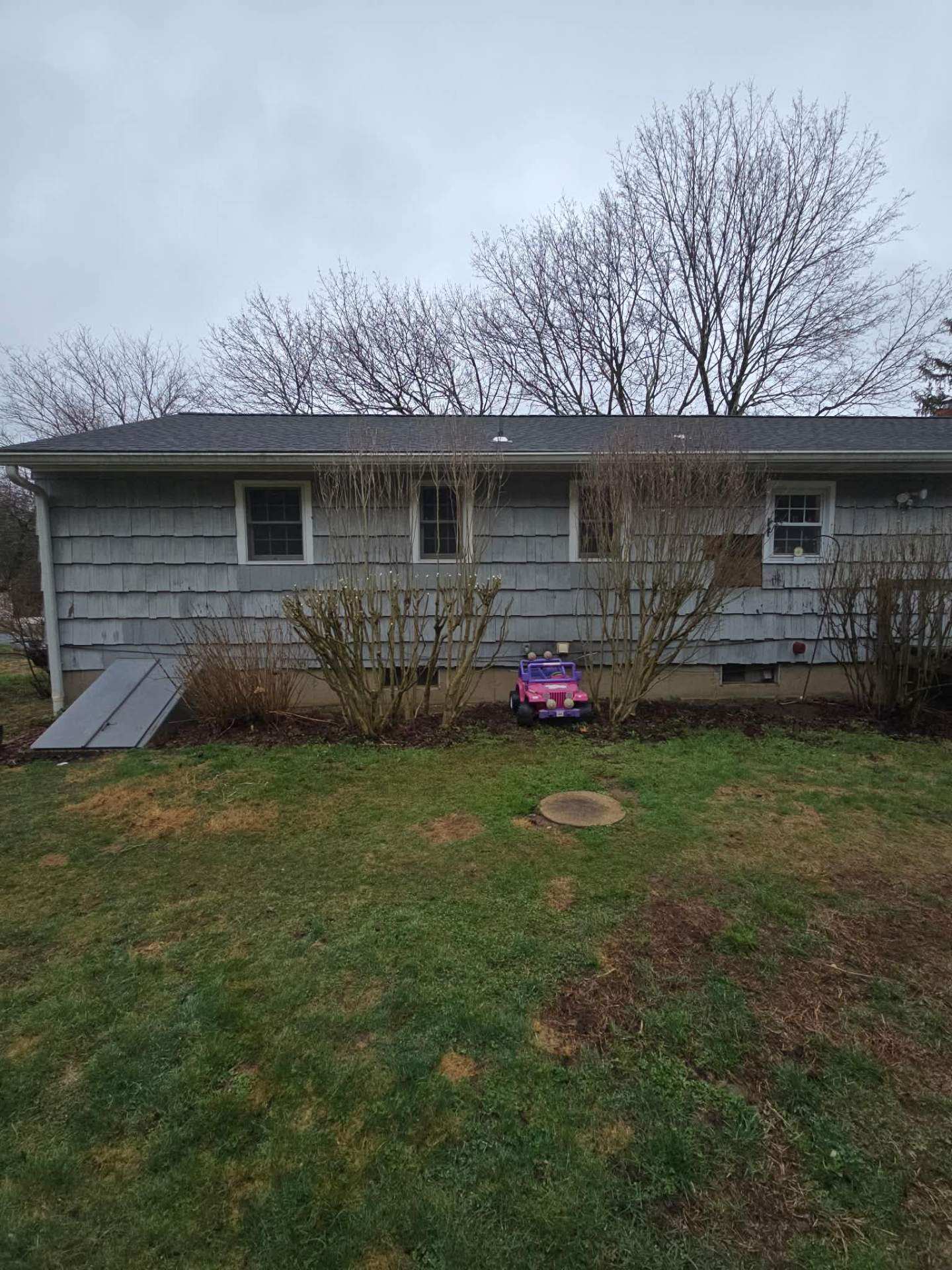 After: same ranch house with the overgrowth removed and the lawn opened up